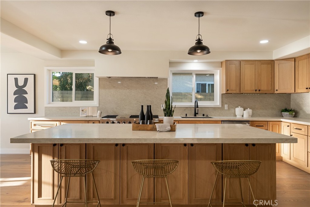 13601 Carroll Way Tustin, CA 92780 - Photo 7 of 28 a kitchen with kitchen island granite countertop a sink and cabinets
