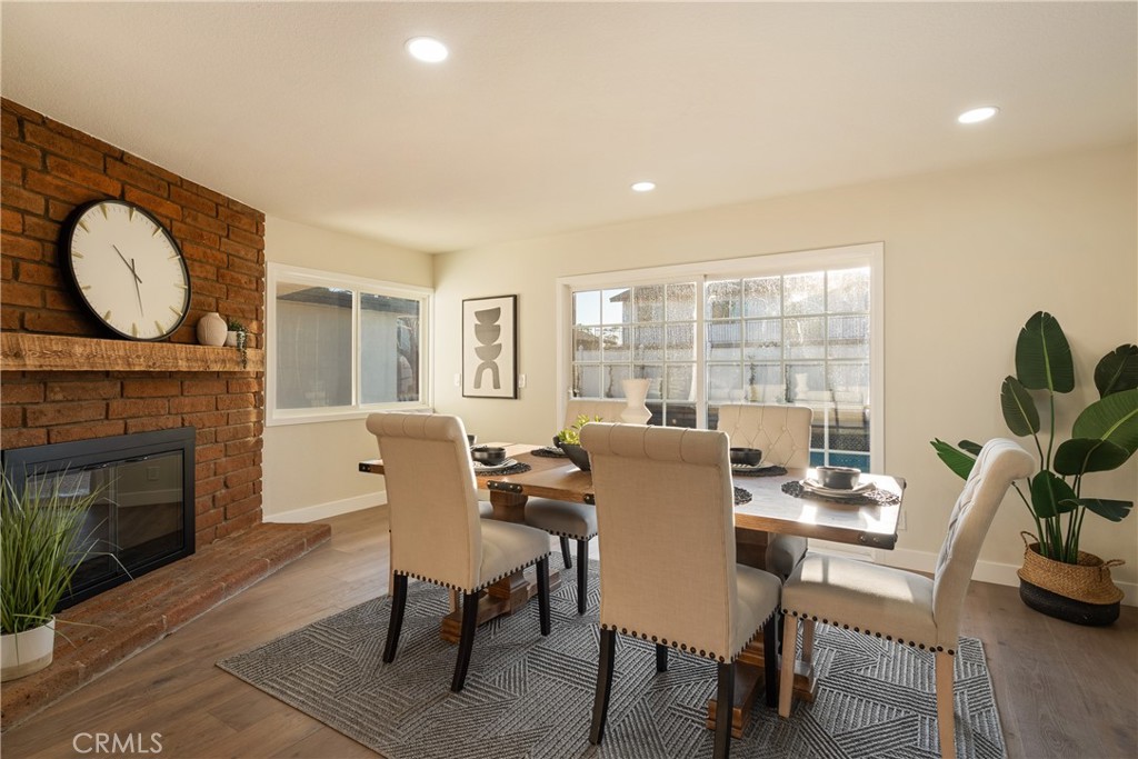 13601 Carroll Way Tustin, CA 92780 - Photo 9 of 28 a dining room with furniture a fireplace and wooden floor