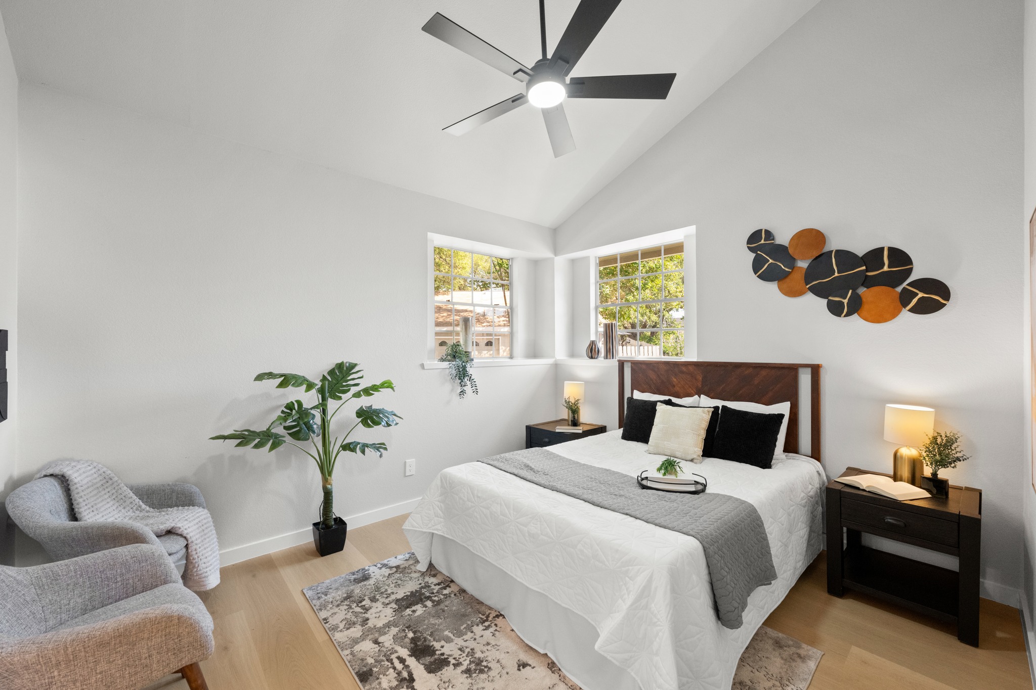 6501 Brush Country Road, Unit 120 Austin, TX 78749 - Photo 11 of 26 Primary bedroom featuring vaulted ceilings, LVP flooring, multiple windows, and a modern ceiling fan