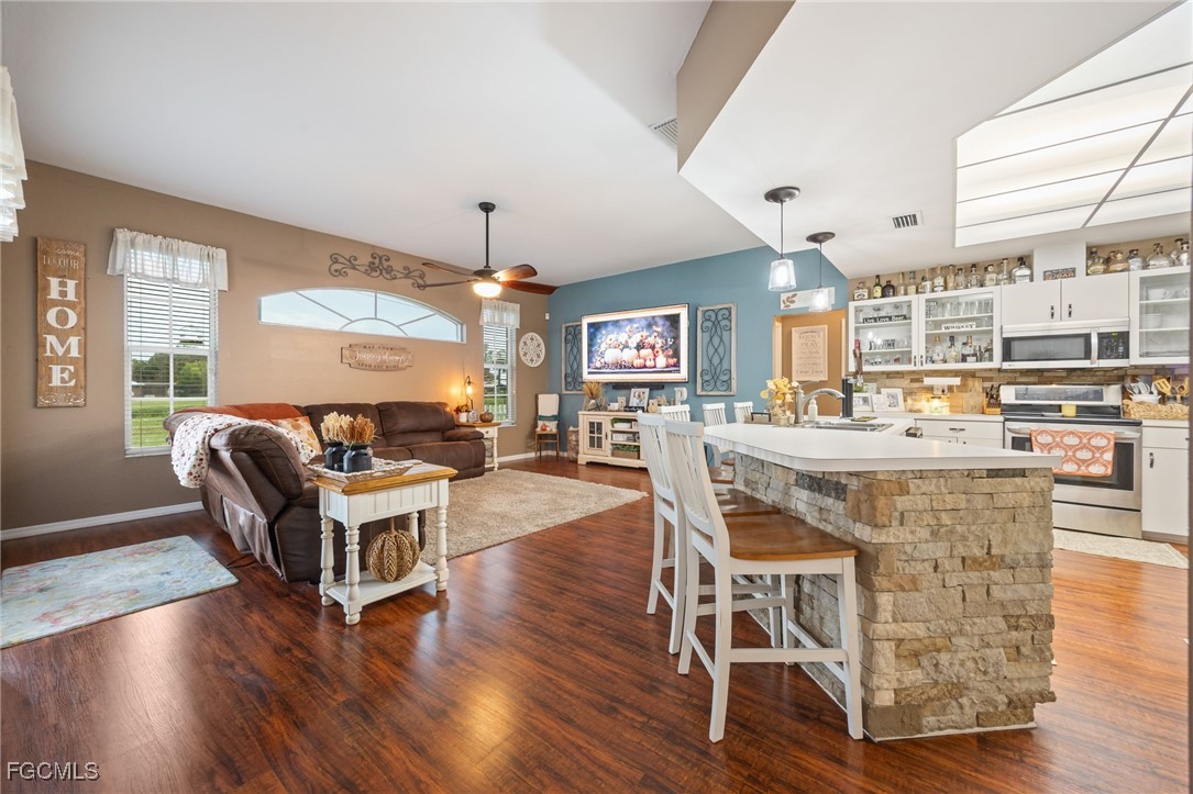 914 Sawgrass Street Clewiston, FL 33440 - Photo 8 of 43 a living room with furniture a dining table and a wooden floor