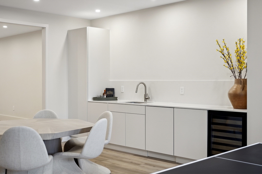 9 Bellevue Road Wellesley, MA 02481 - Photo 32 of 38 a white kitchen with a sink a table and chairs
