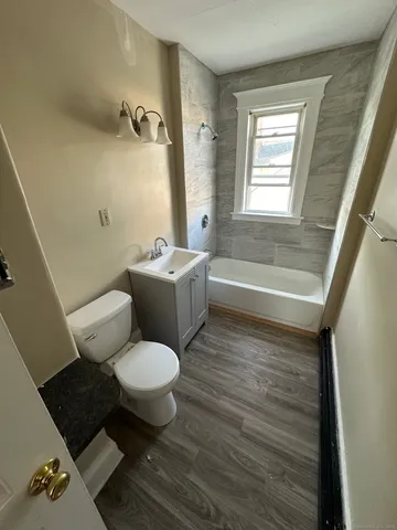 a bathroom with a granite countertop toilet a sink and a bathtub