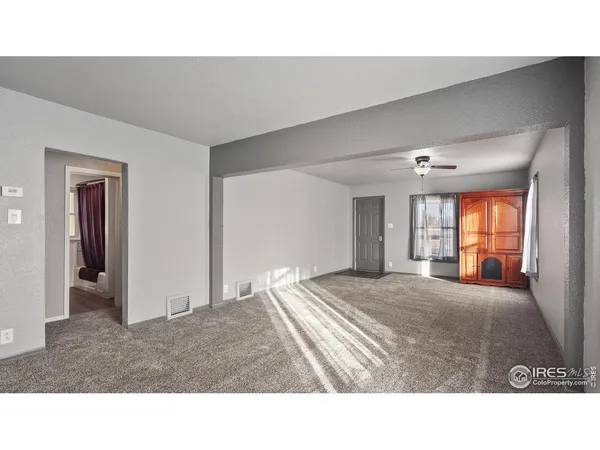 a living room with a bed furniture and a window