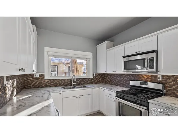 a kitchen with a stove a sink and a microwave