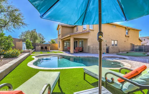 a view of a swimming pool with a yard and sitting area