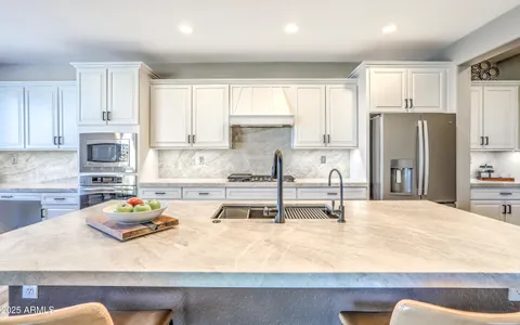a kitchen with stainless steel appliances granite countertop a sink refrigerator and cabinets