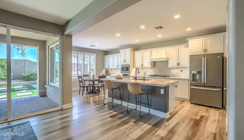 a large kitchen with kitchen island a large counter top space a sink stainless steel appliances and cabinets