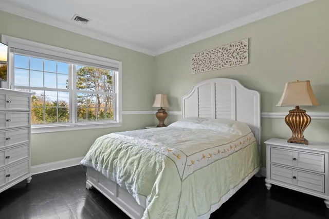 a bedroom with a bed a window and dresser