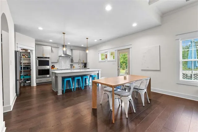 a kitchen with kitchen island a dining table and chairs