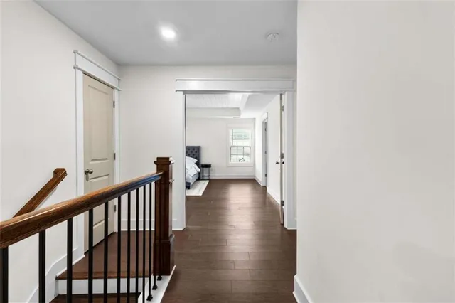 a view of a hallway with wooden floor and stairs