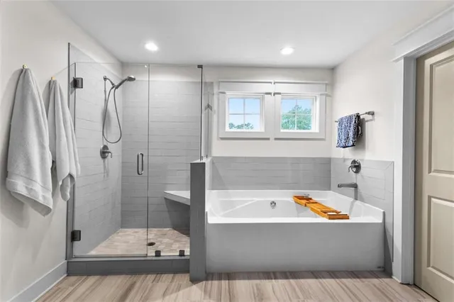 a bathroom with a tub a window and a shower