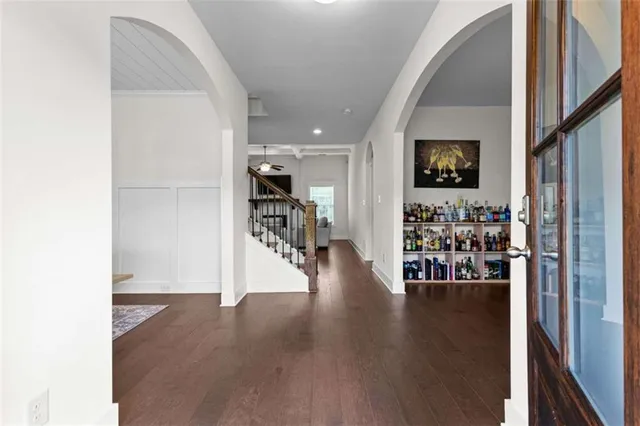 a view of a hallway with wooden floor and a living room