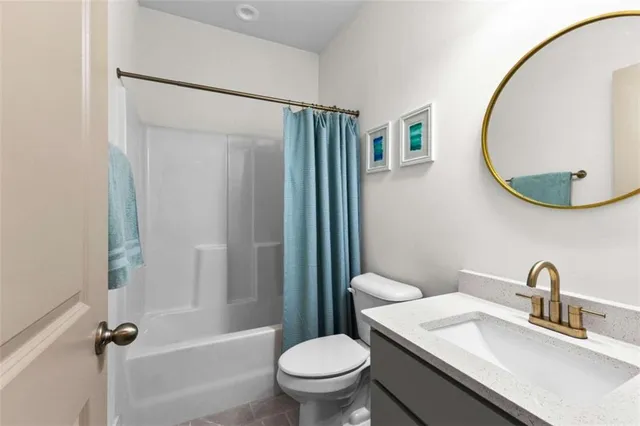 a bathroom with a granite countertop sink toilet and a mirror