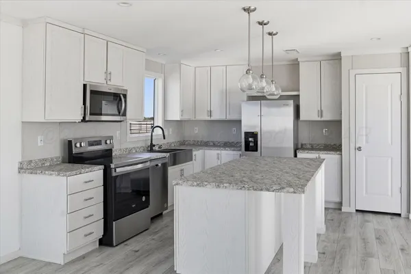 a kitchen with stainless steel appliances granite countertop a sink stove and refrigerator