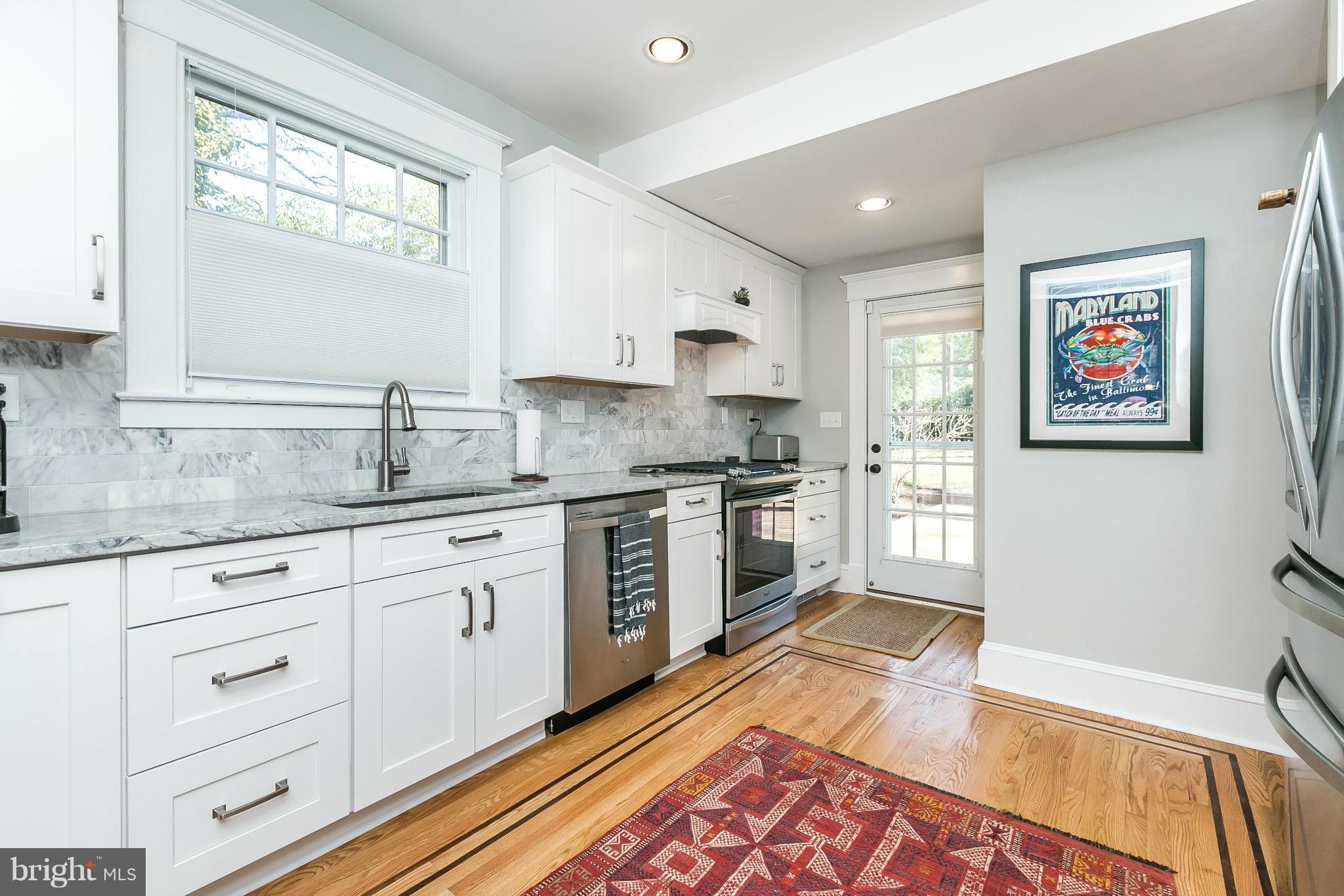 5007 Falls Rd Terrace Baltimore, MD 21210 - Photo 11 of 30 a kitchen with granite countertop a sink cabinets stainless steel appliances and a window