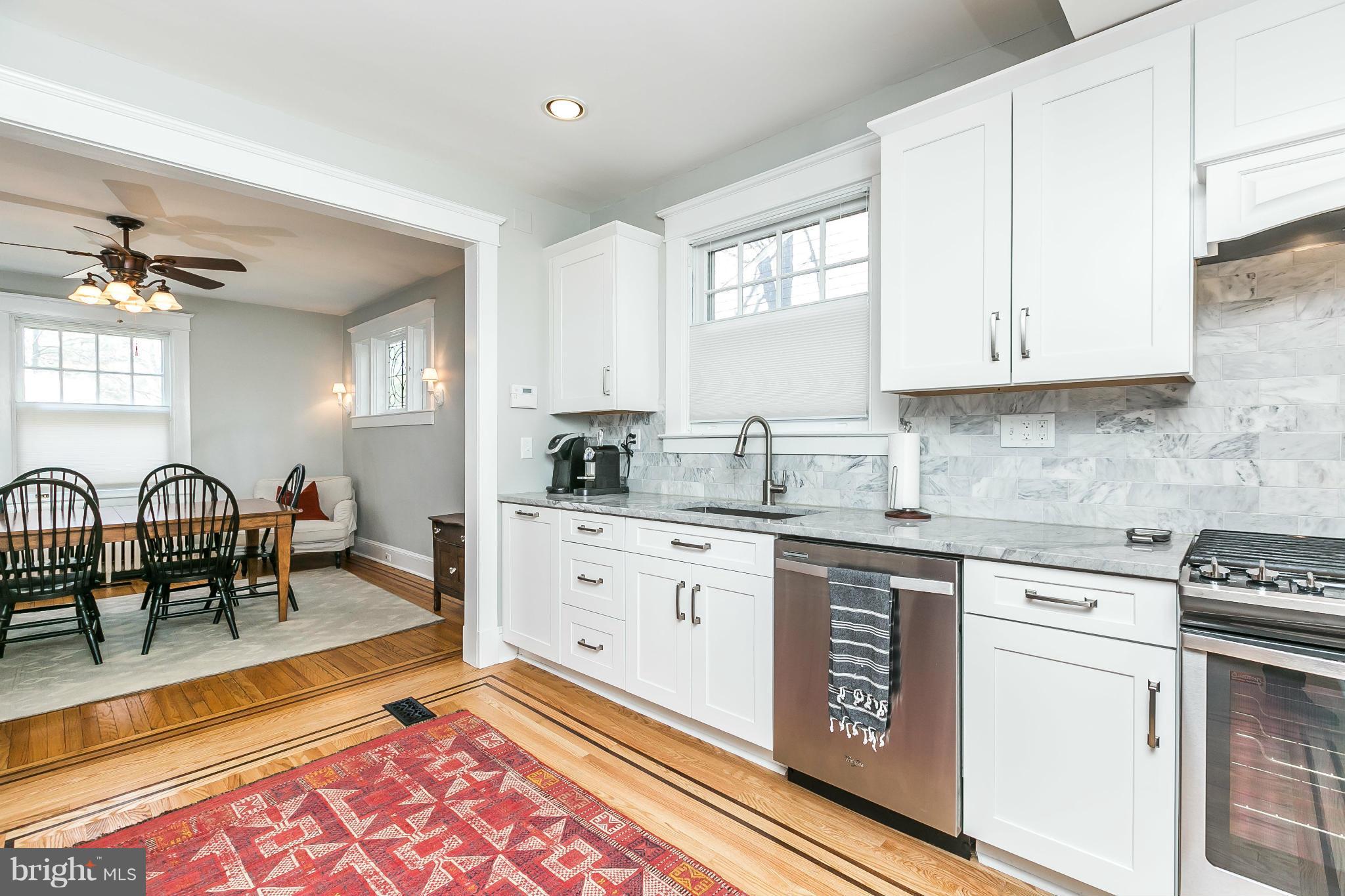 5007 Falls Rd Terrace Baltimore, MD 21210 - Photo 12 of 30 a kitchen with granite countertop a stove top oven a sink a dining table and chairs