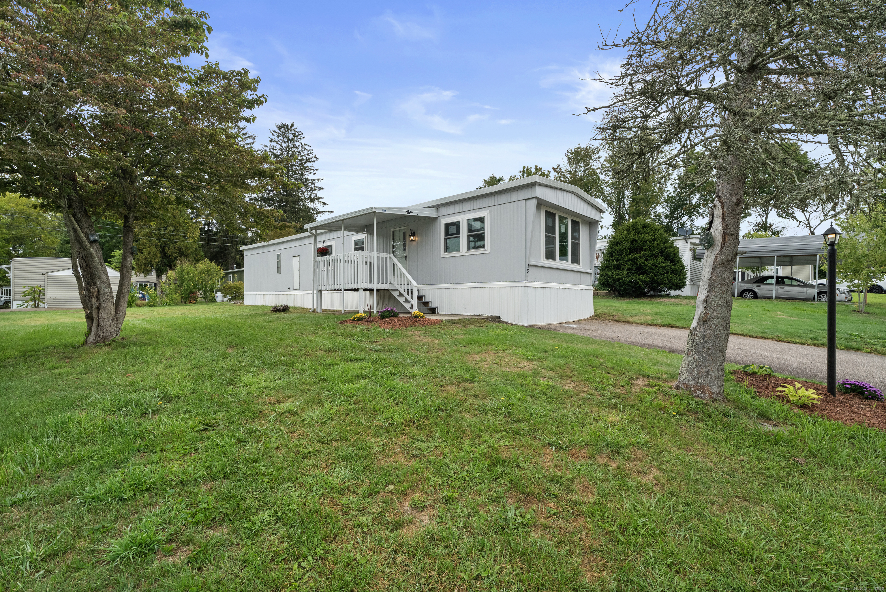 80 Sheldon Road Griswold, CT 06351 - Photo 18 of 24 a house that is sitting in the grass with large trees and plants