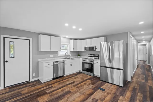 a kitchen with granite countertop stainless steel appliances a refrigerator and a sink