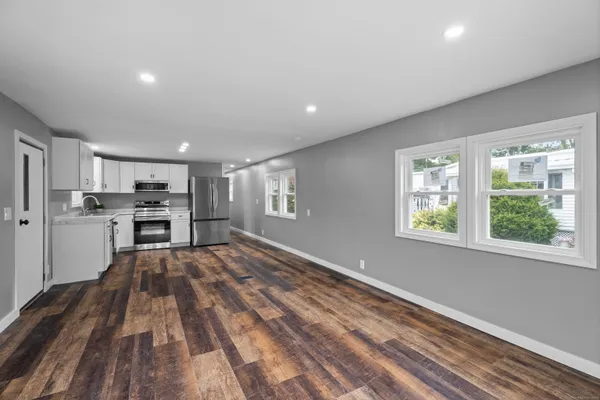 a view of kitchen with wooden floor electronic appliances and window