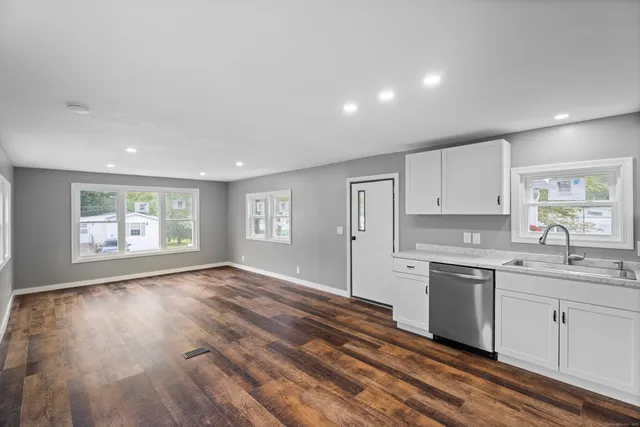 a kitchen with a sink cabinets and wooden floor