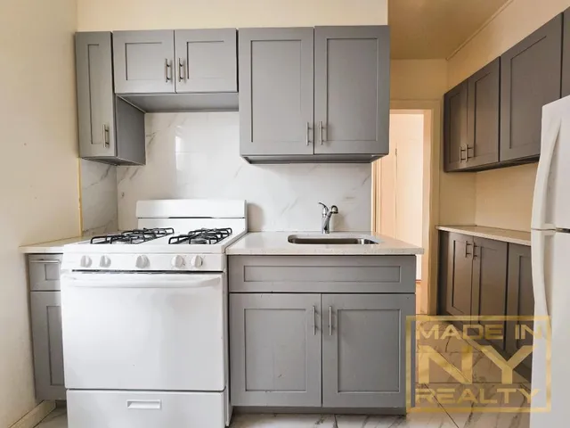 a kitchen with stainless steel appliances granite countertop a sink stove and cabinets