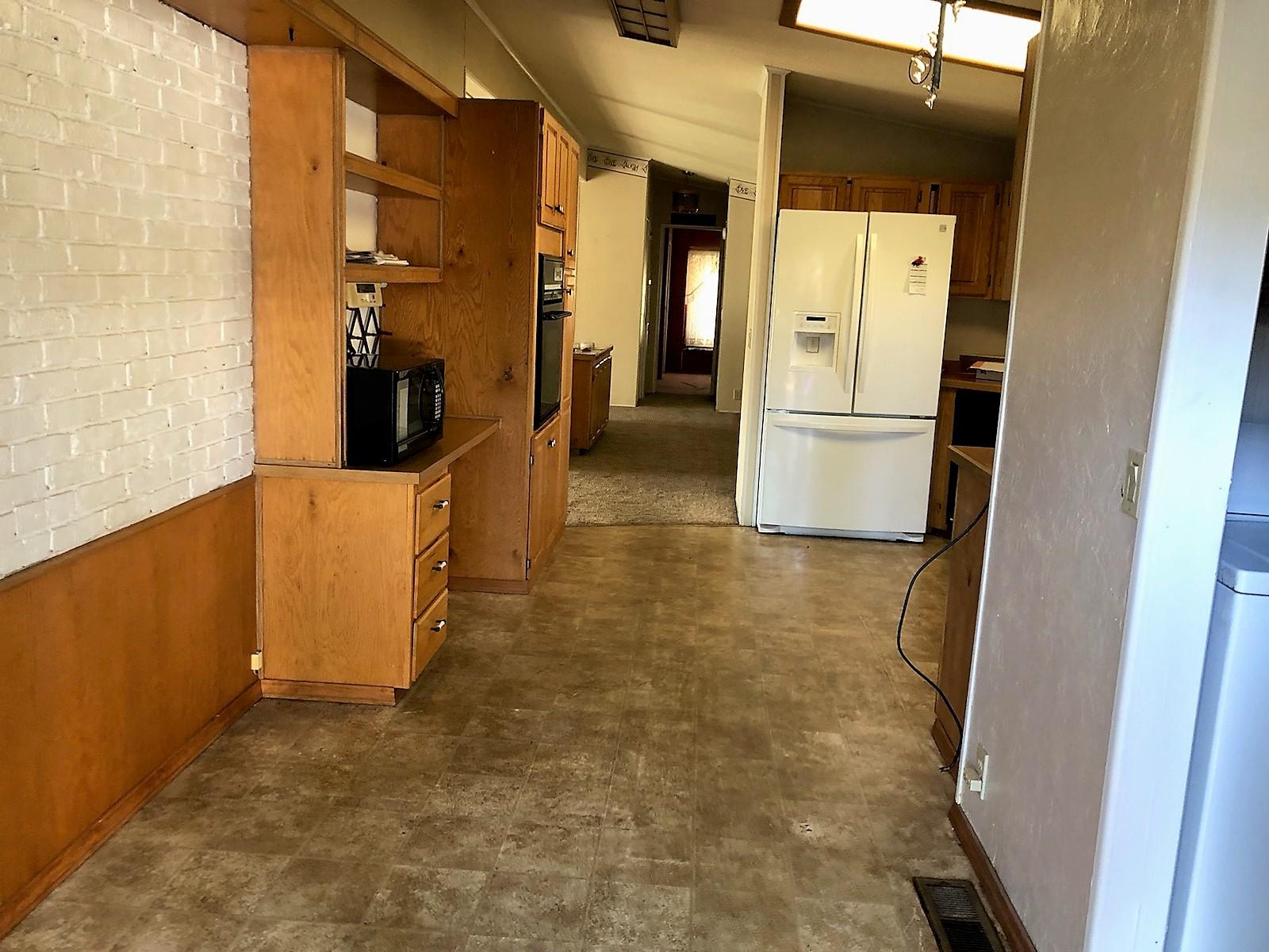 22325 Brent Road Red Bluff, CA 96080 - Photo 8 of 36 a view of a refrigerator in kitchen and an empty room