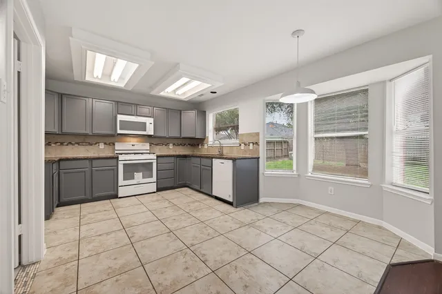 a kitchen with a stove a sink dishwasher a refrigerator and cabinets