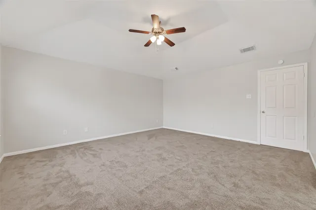 an empty room with closet and fan