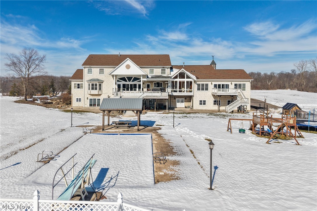 9419 Robinson Road Chardon, OH 44024 - Photo 11 of 46 Snow covered property with a patio area, in-ground pool, a balcony, and a trampoline