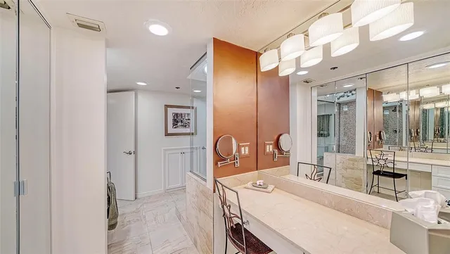 a bathroom with a granite countertop sink mirror vanity and toilet