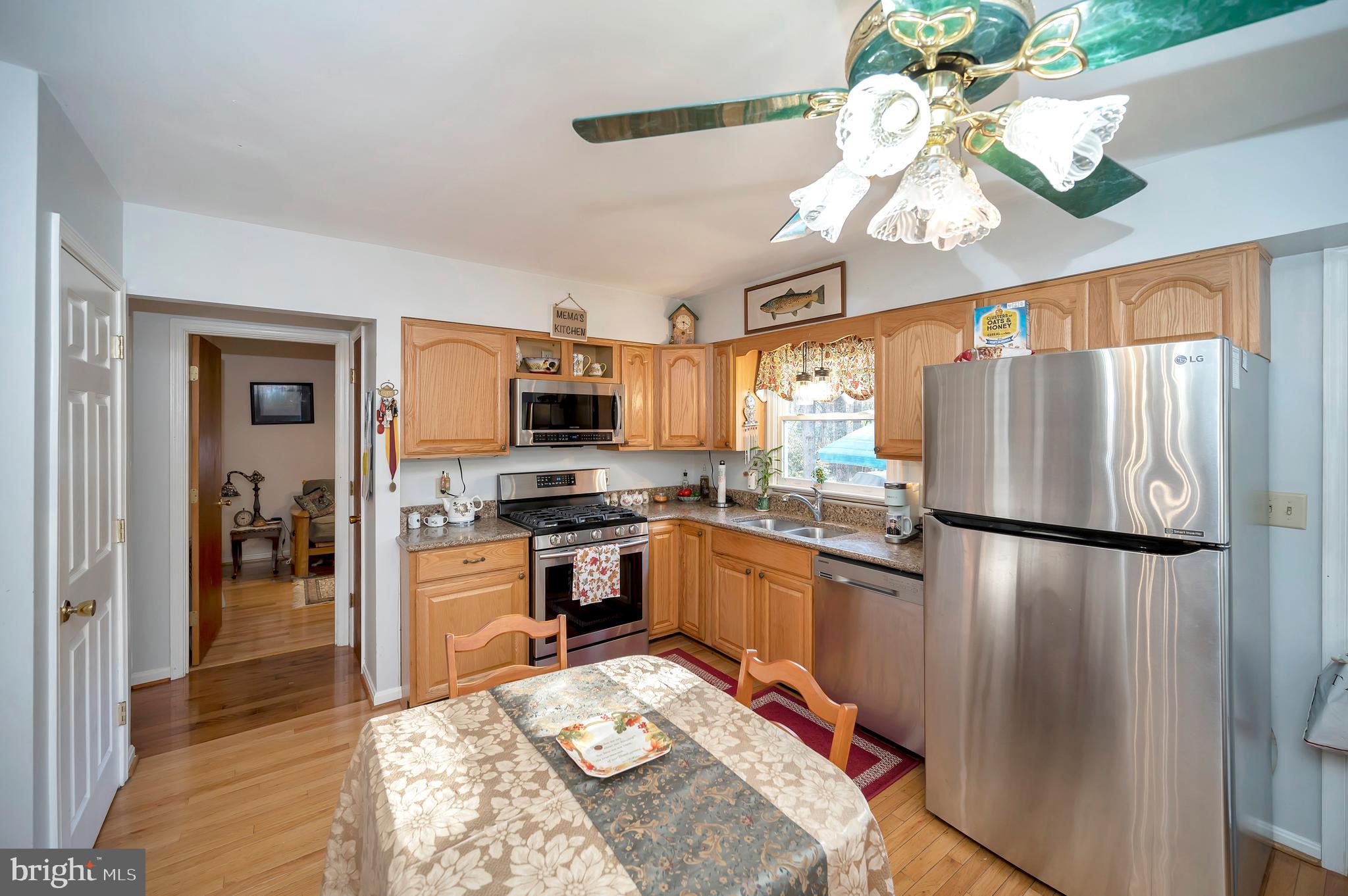 18 Winslow Road Fredericksburg, VA 22406 - Photo 11 of 49 a kitchen with stainless steel appliances granite countertop a refrigerator a stove a sink dishwasher and a dining table with wooden floor