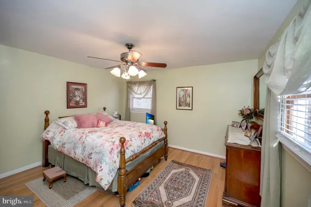 a bedroom with a bed chandelier and a window