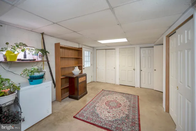 a view of a hallway to room and kitchen with wooden floor