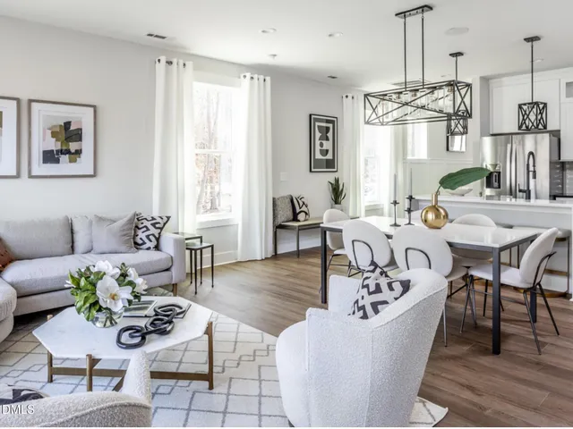 a living room with furniture dining table and a chandelier