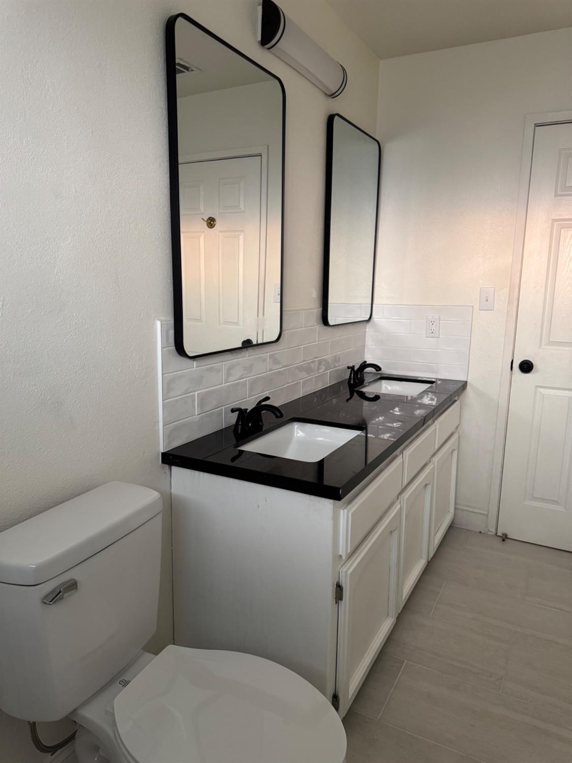 17269 Mark Road Madera, CA 93636 - Photo 8 of 23 a bathroom with a granite countertop toilet a sink and a mirror