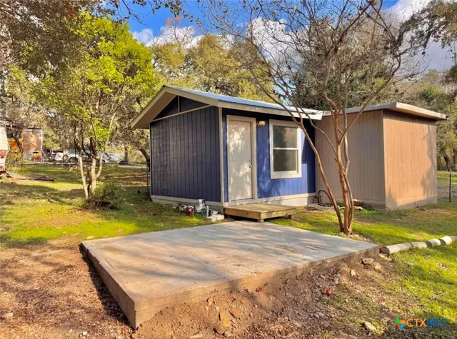 a backyard of a house with swimming pool and large trees