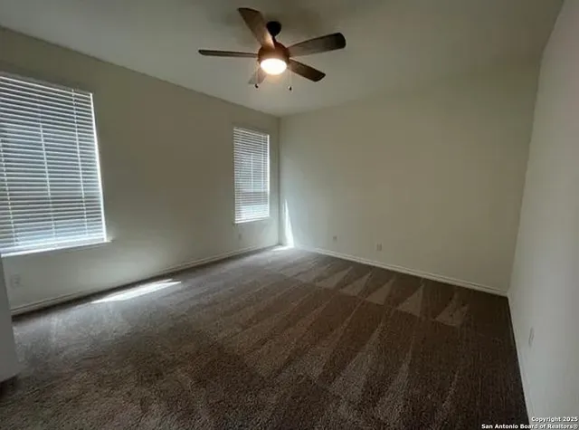 a view of empty room with ceiling fan