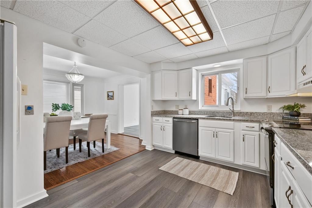2923 Fernwald Road Pittsburgh, PA 15217 - Photo 8 of 36 a kitchen with stainless steel appliances granite countertop a stove a sink dishwasher a microwave oven a stove with white cabinets and wooden floor
