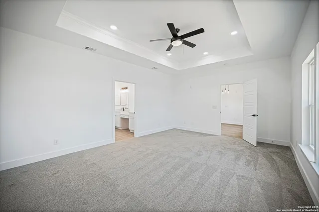 an empty room with a window and a fan