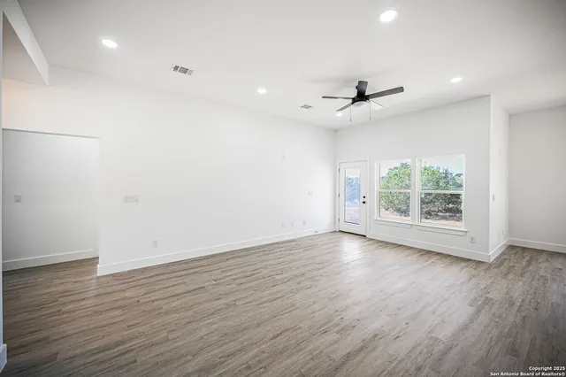 a kitchen with a sink stove and wooden floor