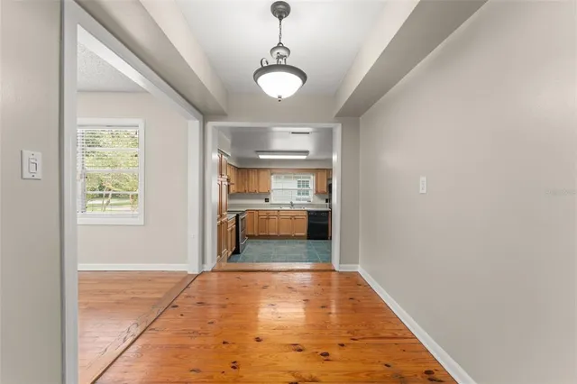a view of a hallway to a livingroom with wooden floor