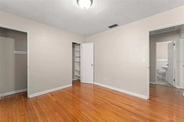 a view of an empty room with wooden floor