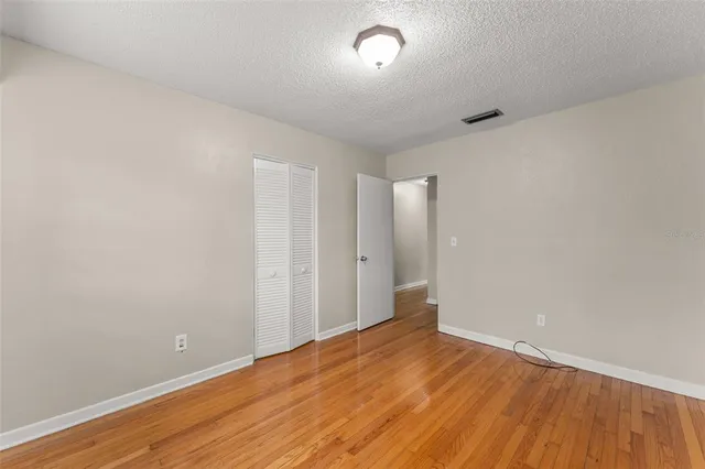 a view of an empty room with wooden floor