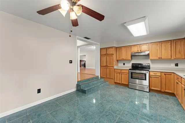 a kitchen with granite countertop a refrigerator oven a sink and dishwasher