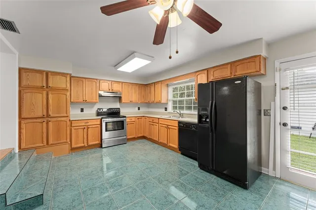 a kitchen with stainless steel appliances a refrigerator a sink a stove and cabinets