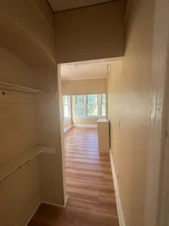 a view of a hallway with wooden floor and windows
