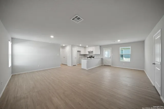 a view of empty room with wooden floor