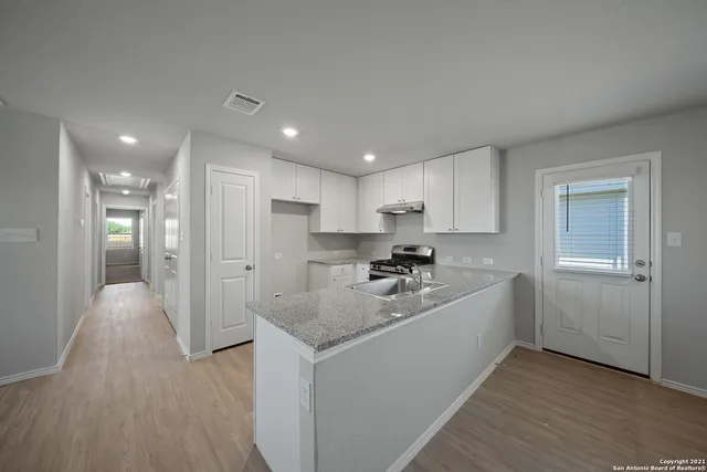 a kitchen with a refrigerator sink and cabinets