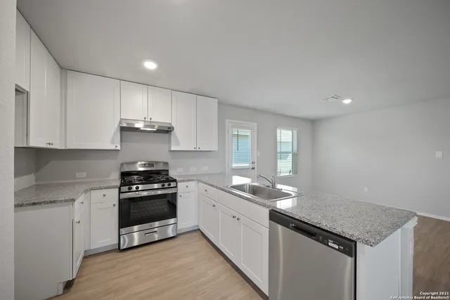 a kitchen with stainless steel appliances granite countertop a stove a sink and a refrigerator