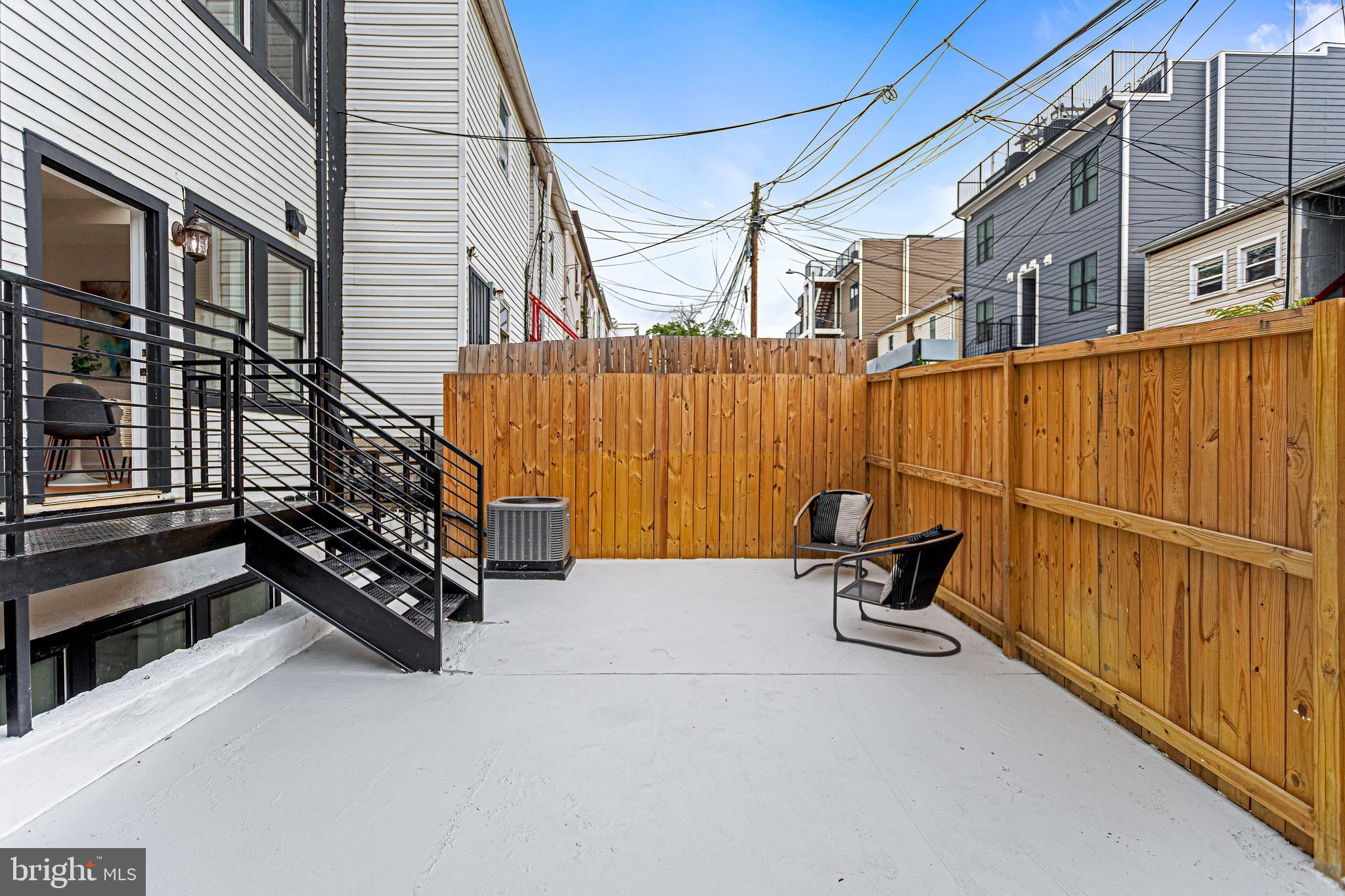 1107 Queen Street Northeast, Unit PH4 Washington, DC 20002 - Photo 24 of 28 a backyard of a house with table and chairs